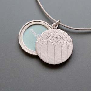 minimalistic silver photo locket with forest design