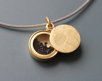 elegant golden remembrance locket filled with forget me not seeds