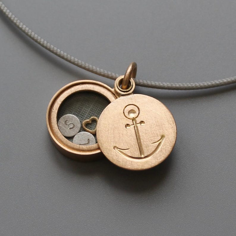 rosegold floating locket with anchor engraved on the lid filled with initials and heart