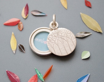 minimalistic silver locket for a small picture with forest design