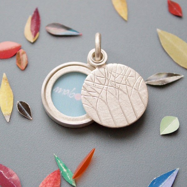 minimalistic silver locket for a small picture with forest design