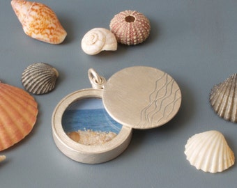 floating glass locket filled with seashells and waves design