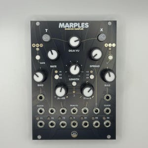 May include: Black electronic music synthesizer module with the text "MARPLES RANDOM SAMPLER". It features numerous knobs, jacks, and labels including "DEJA VU", "RATE", "LENGTH", and "SPREAD". The module has a sleek, modern design with white and gold accents.