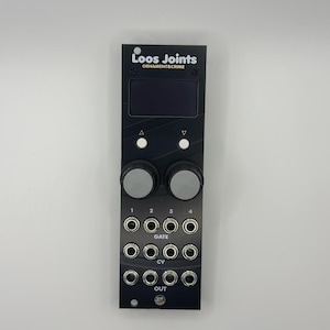 May include: Black electronic device with the text "Loos Joints ORNAMENT&CRIME". It features a screen, two knobs, multiple input jacks, and the labels "GATE", "CV", and "OUT". The device has a sleek, modern design.