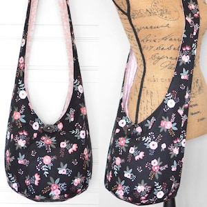 May include: A black shoulder bag with a floral pattern, featuring pink, white, and teal flowers. It has a pink polka dot lining and a long strap. The bag is secured with a button closure.