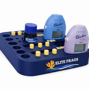May include: A navy blue testing kit with the text "ELITE FRAGS" and a coral logo. The kit holds a bottle, two Hanna Checkers, and several yellow cylinders. The Hanna Checkers are blue and purple.