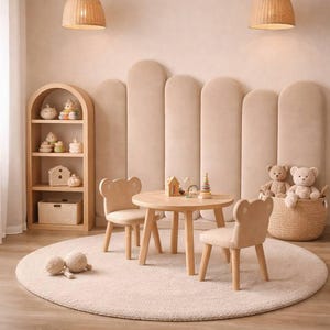 May include: A child's playroom featuring a round wooden table and two bear-shaped chairs. A wooden bookshelf, a woven basket, and a round rug complete the scene. Two woven pendant lights hang from the ceiling. The room is decorated in neutral tones.