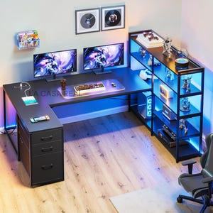 May include: A black L-shaped gaming desk with a built-in shelf unit, illuminated with blue LED lights. The desk features two monitors, a keyboard, and a mouse. A tablet and a game console are on the desk. The shelf displays figurines and gaming accessories.