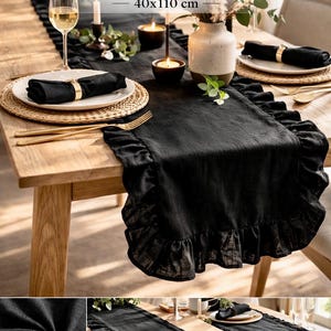 May include: Black linen table runner, 40x110 cm, with a ruffled edge, displayed on a wooden table. The table is set with plates, napkins, and gold-colored cutlery. Candles and a vase with flowers add to the elegant setting.