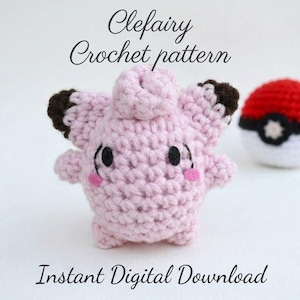 Könnte beinhalten: Eine hellrosa gehäkelte Clefairy-Figur mit dunkelbraunen Ohrspitzen, schwarzen Augen und rosa Filzwangen, begleitet von einem rot-weiß-schwarzen gehäkelten Ball. Der Text lautet Clefairy Crochet pattern und Instant Digital Download.