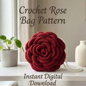 May include: A deep red crochet bag shaped like a rose with a white pearl bead strap. The text above reads Crochet Rose Bag Pattern and the text below reads Instant Digital Download. The bag is positioned on a white surface.