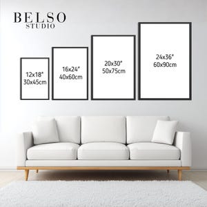 May include: Four framed art prints of varying sizes, displayed above a white sofa and a white rug. The frames are black, and the prints are blank. The sizes are 12x18 inches, 16x24 inches, 20x30 inches, and 24x36 inches.