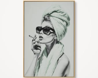 May include: Black and white framed art print of a woman wearing sunglasses and a towel wrapped around her head, smoking a cigarette. The artwork has a vintage, glamorous aesthetic.