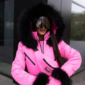 Traje de esquí rosa, ribete de piel negra y mono de invierno con capucha