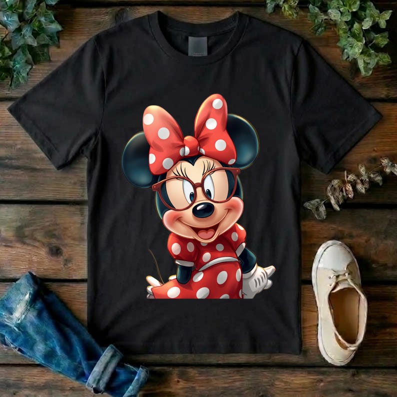 May include: A black short-sleeved t-shirt featuring a graphic of a cartoon mouse wearing red-rimmed glasses and a large red bow with white polka dots. The mouse is also wearing a matching red dress with white polka dots and white gloves.