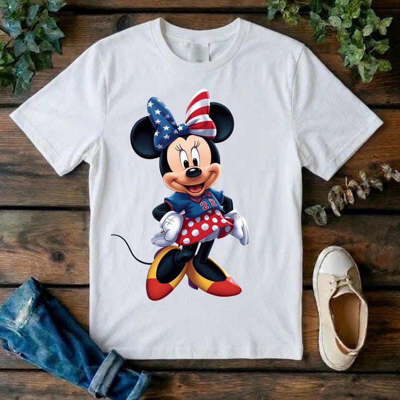 May include: A white short-sleeved t-shirt featuring a graphic of Minnie Mouse wearing a blue and red star-patterned bow, a blue top with the number 22, a red skirt with white polka dots, and yellow and red shoes on a plain white background.