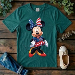 May include: A dark green short-sleeved t-shirt featuring a graphic of Minnie Mouse wearing a bow with a blue and white star pattern and red and white stripes, a blue top with the number 22, and a red skirt with white polka dots and yellow shoes.