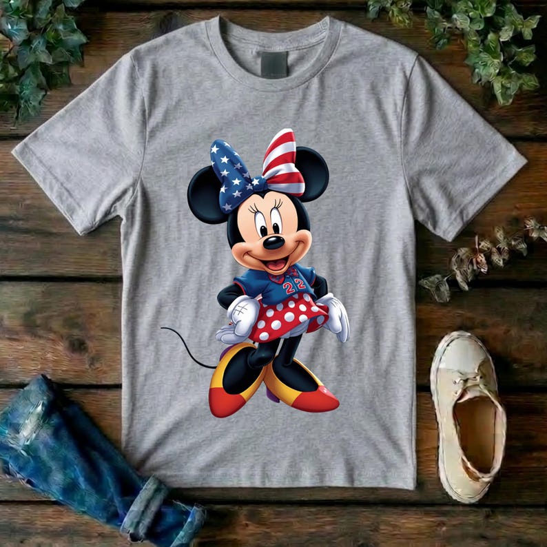 May include: A heather gray short-sleeve t-shirt featuring a graphic of Minnie Mouse wearing a red, white, and blue star-spangled bow, a blue top with the number 22, a red and white polka-dot skirt, and yellow shoes with red accents.
