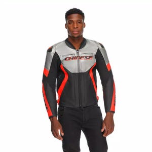 May include: A black, silver, and red motorcycle jacket with the brand name "DAINESE" in red lettering across the chest. The jacket has a zip-up front, padded shoulders, and red accents on the sleeves. The model is wearing black pants.