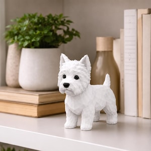 May include: A white West Highland White Terrier figurine featuring a geometric, faceted surface design. The dog sculpture has pointed ears, a short tail, and black eyes and nose, standing in a rigid, alert pose on a flat, light-colored surface.