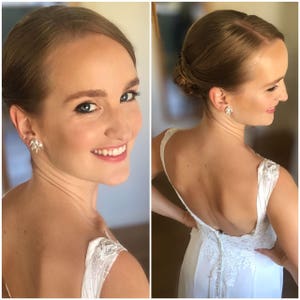 May include: A bride with her hair pulled back in a low bun, wearing a white lace wedding dress with a low back.