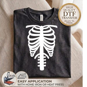 May include: A dark charcoal gray t-shirt featuring a large, white, graphic print of a human rib cage and spine on the front. A circular gold badge in the top right corner reads High Quality DTF Transfer Ready To Press, with application icons below.