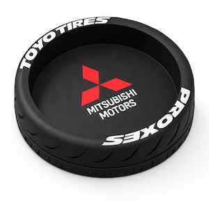 Puede incluir: Bandeja negra con forma de neumático con texto blanco "TOYO TIRES" y "PROXES". El centro presenta el logotipo de Mitsubishi Motors en rojo y texto blanco. La bandeja tiene un diseño de banda de rodadura.
