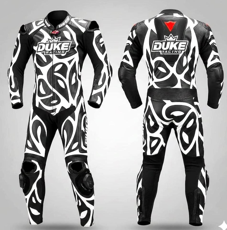 May include: A black and white motorcycle racing suit with a distinctive pattern. The suit displays the "DUKE RACING" logo on the chest and back. The suit includes protective padding on the shoulders, elbows, and knees.