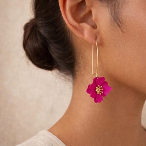Peut inclure: Boucles d'oreilles pendantes dorées avec une fleur fuchsia vif et un centre doré. Les boucles d'oreilles ont un long fil d'or fin qui pend de l'oreille. La fleur mesure environ 3 cm de diamètre.