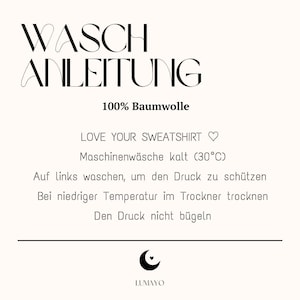 May include: A cream-colored graphic with black text that reads "WASCH ANLEITUNG" and "100% Baumwolle." Below, it says "LOVE YOUR SWEATSHIRT" and washing instructions. The LUMAYO logo is at the bottom.