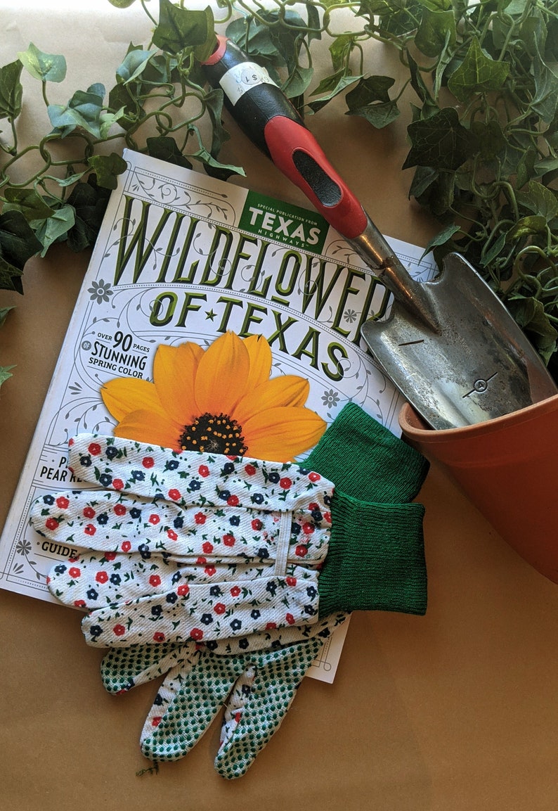 May include: A gardening kit with a pair of floral print gardening gloves, a small trowel, a terracotta pot, and a magazine titled "Wildflower of Texas" with a yellow flower on the cover.