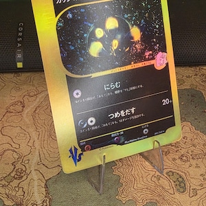 Op de afbeelding: Een goudkleurige ruilkaart met de Japanse tekst "カリンのブラッキー" bovenaan, een illustratie van een donker wezen met gele accenten tegen een sterrenachtergrond, HP60 en twee aanvalsbeschrijvingen met Japanse tekst en symbolen.