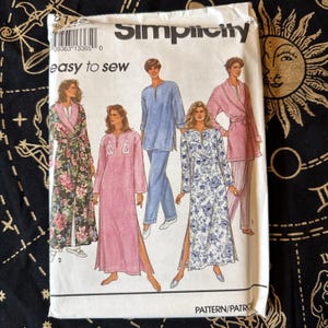 Puede incluir: Un sobre de patrón Simplicity 8142 easy to sew con ilustraciones de cuatro estilos diferentes de ropa de estar por casa, incluyendo una bata floral, un camisón rosa liso, una túnica azul con pantalones y un camisón azul floral con una bata rosa a juego.