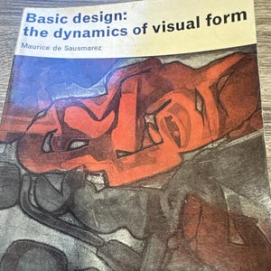 May include: A softcover book titled Basic design: the dynamics of visual form by Maurice de Sausmarez. The cover features a white top section with black text and a large, abstract graphic illustration in shades of red, black, and gray below.