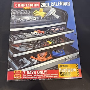 May include: A Craftsman 2001 calendar featuring a detailed illustration of a tool chest filled with various tools. The calendar has a blue background with the text "Craftsman" and "2001 Calendar". The bottom of the calendar has a red banner with the text "7 Days Only!" and "Sears National Hardware Sale".