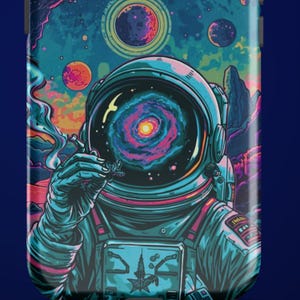 May include: A phone case featuring a vibrant illustration of an astronaut in a space suit. The astronaut's helmet displays a colorful galaxy, and the background showcases planets and nebulae in shades of blue, purple, and orange.
