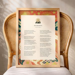 Puede incluir: Una lámina enmarcada con el poema Desiderata de Max Ehrmann. La obra tiene un centro color crema con texto en negro, rodeado por un borde vibrante con patrones inspirados en el desierto, soles y cactus en rojo, naranja, amarillo y verde.
