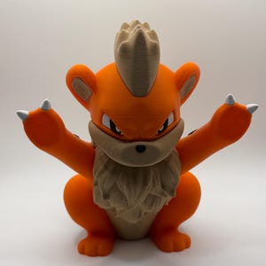 May include: A 3D printed figurine of a creature with bright orange fur, a tan mane, and a tan crest on its head. The creature has pointed ears, a small black nose, and white claws on its raised paws. It features a textured surface finish.