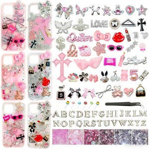 Può includere: Una collezione di custodie per telefoni e abbellimenti decorativi. Le custodie sono trasparenti con accenti rosa e argento, con fiocchi, croci e altri ciondoli. Ulteriori ciondoli includono rossetti, occhiali da sole e lettere. Sono esposti anche una varietà di elementi decorativi rosa e argento.