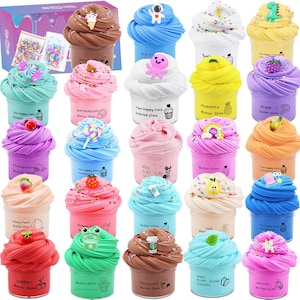 Pode incluir: Uma coleção de recipientes coloridos de slime de manteiga com várias coberturas e aromas. Cada recipiente é decorado com um charme diferente, como um unicórnio, um dinossauro ou uma fruta. Os recipientes estão dispostos em filas e colunas.