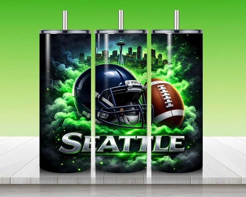 Puede incluir: Un juego de tres vasos de acero inoxidable con tem&aacute;tica de los Seattle Seahawks. Cada vaso presenta un casco de f&uacute;tbol azul oscuro y un bal&oacute;n de f&uacute;tbol marr&oacute;n sobre un fondo de paisaje urbano y humo verde. La palabra "SEATTLE" se muestra en letras plateadas.
