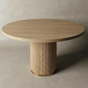 May include: A round wooden dining table with a light brown finish. The tabletop rests on a cylindrical base with vertical grooved detailing. A brass-colored band accents the base. The table is set against a neutral background.