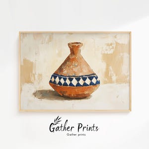 May include: A framed print of a terracotta-colored vase with a blue and white diamond pattern. The vase is set against a neutral background with visible brushstrokes. The print is signed "Gather Prints".