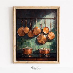 May include: A framed print of a kitchen scene. Copper pots and pans hang from a rack against a green tiled wall. Two copper pots sit on a black stovetop. The artwork has a vintage, rustic aesthetic.
