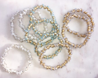 stackable bracelets . gold, aqua, frosty white, silver, baby blue stretch cord . 1 bracelet