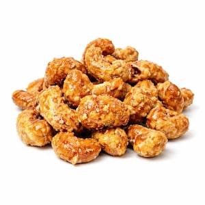 Könnte beinhalten: Nahaufnahme eines Haufens glasierter Cashewnüsse. Die Nüsse haben eine glänzende, goldbraune Beschichtung und sind zusammengeballt. Die Cashewnüsse scheinen kandiert oder mit einer süßen Glasur überzogen zu sein, wodurch ihre unregelmäßigen Formen und Texturen sichtbar werden.
