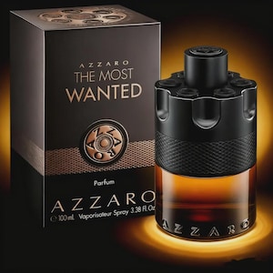 May include: Azzaro "The Most Wanted" perfume bottle and box. The bottle is black with a textured grip and a unique top design. The box is black with gold lettering and a circular emblem. The bottle contains 3.38 fl oz (100 ml) of perfume.