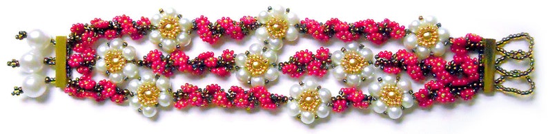 Puede incluir: Un brazalete de m&uacute;ltiples hilos con cuentas rosas, marrones y doradas. El brazalete presenta cuentas blancas nacaradas y peque&ntilde;as cuentas doradas en el centro de cada dise&ntilde;o con forma de flor.