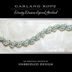 Peut inclure: Une guirlande de perles délicate en blanc et bleu clair avec un motif en spirale. La guirlande est faite de petites perles enfilées pour créer un motif floral. La guirlande s'appelle "Dainty Daisies Spiral Garland" et est un design original d'Unbridled Design.