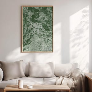 Peut inclure: Une œuvre d'art murale rectangulaire présentant un motif abstrait et texturé dans des tons de vert forêt profond et de sauge atténué. L'œuvre est encadrée dans un cadre en bois clair et est exposée verticalement, révélant une surface organique.